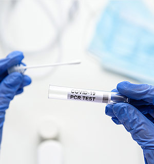 Healthcare worker holding a vial of a COVID-19 PCR test