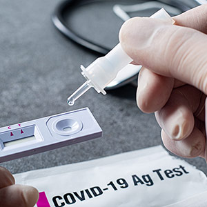 Healthcare worker holding a COVID rapid antigen test