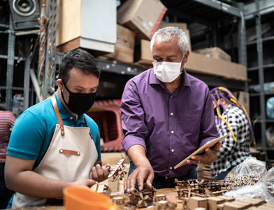 Men working in a workshop while wearing masks
