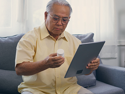 Elderly patient video call by digital tablet to doctor for inquire about which bottle of medication pills 