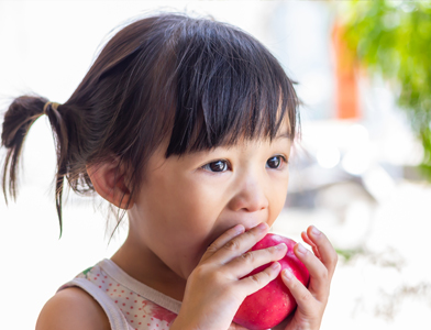 young girl eating an apple