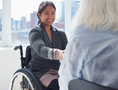 Women in wheelchair shaking hands