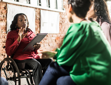 Woman in wheelchair talking to two other people